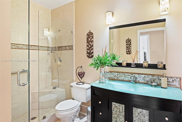 bathroom with decorative backsplash, a shower stall, toilet, and vanity