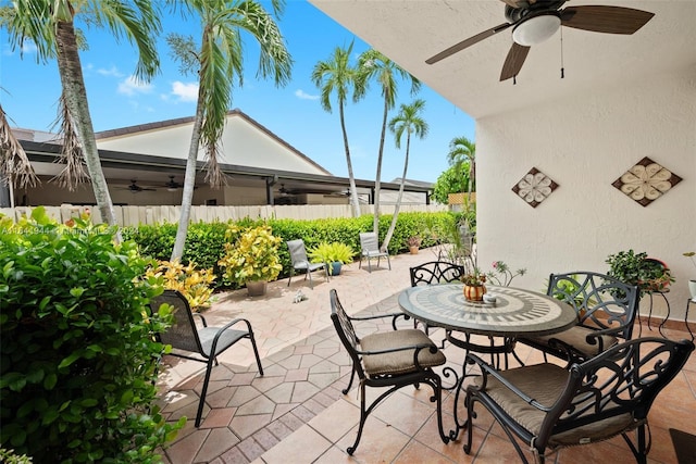 view of patio / terrace with outdoor dining area, fence, and a ceiling fan