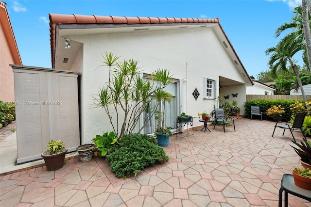 back of property with fence, a patio, and stucco siding