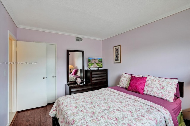 bedroom with a closet, dark hardwood / wood-style floors, and ornamental molding