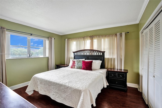 bedroom with a closet, a textured ceiling, dark hardwood / wood-style floors, and ornamental molding