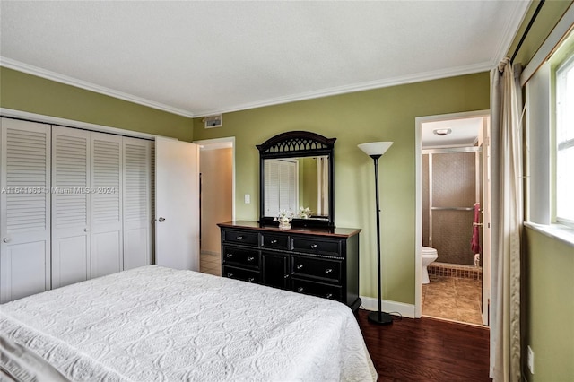 bedroom with dark hardwood / wood-style floors, ornamental molding, a closet, and ensuite bath