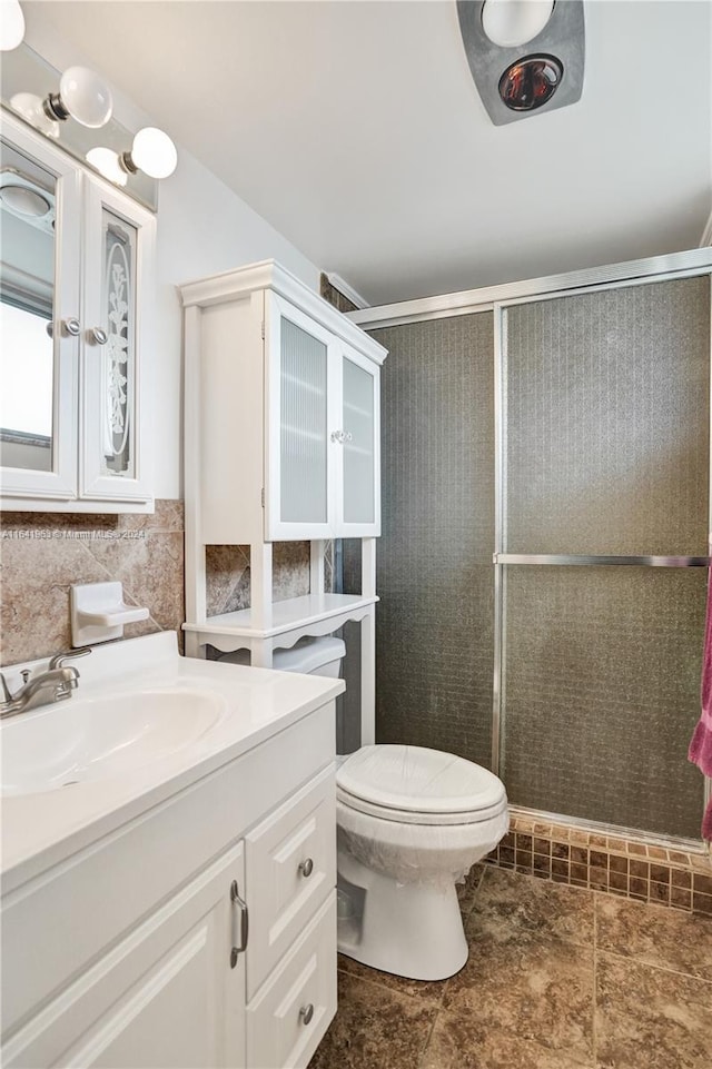 bathroom featuring backsplash, tile patterned floors, vanity, toilet, and walk in shower