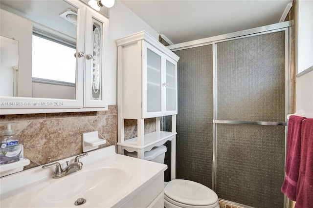 bathroom with backsplash, toilet, vanity, tile walls, and a shower with shower door