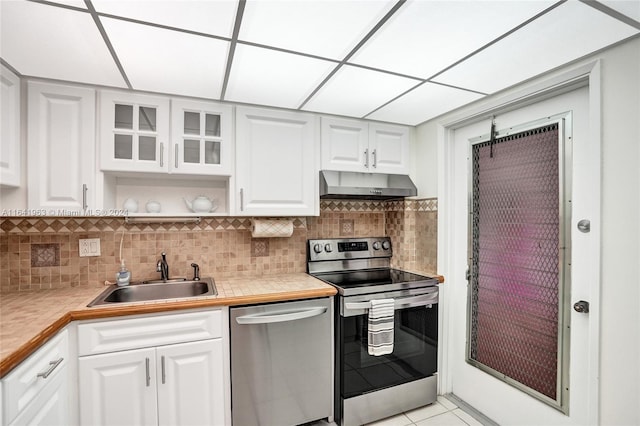 kitchen featuring light tile patterned flooring, backsplash, sink, stainless steel dishwasher, and electric stove