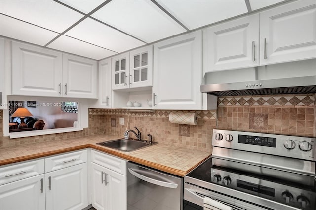 kitchen with sink, tasteful backsplash, white cabinetry, and stainless steel appliances