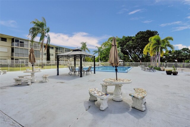 view of property's community with a swimming pool, a gazebo, and a patio area