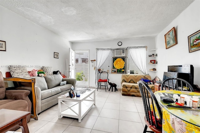 living room featuring light tile patterned flooring, a textured ceiling, and a wall unit AC