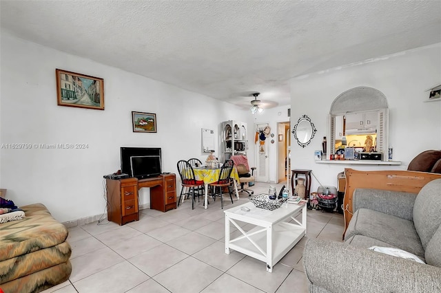 tiled living room featuring ceiling fan and a textured ceiling