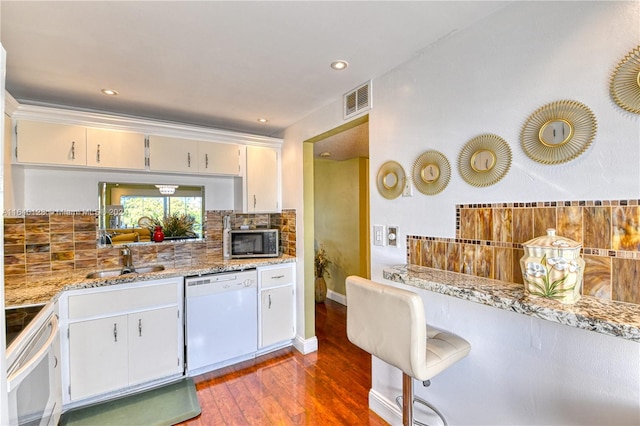 kitchen with dishwasher, sink, wood-type flooring, decorative backsplash, and stove