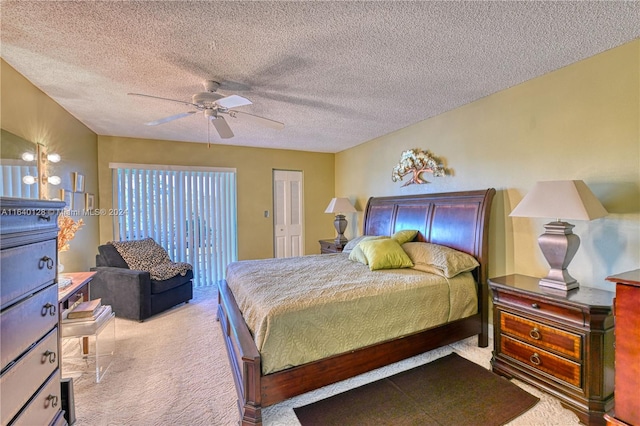 bedroom with ceiling fan, a textured ceiling, light carpet, and a closet