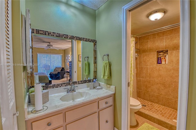 bathroom featuring ceiling fan, curtained shower, toilet, vanity, and tile patterned flooring