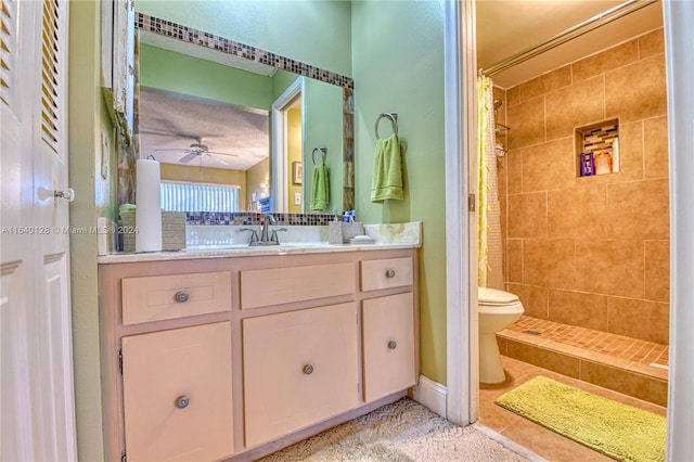 bathroom with toilet, ceiling fan, tile patterned flooring, walk in shower, and vanity