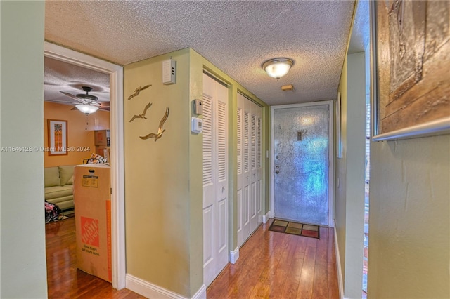 hallway with wood-type flooring and a textured ceiling