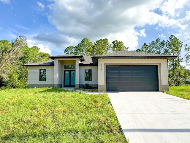 prairie-style house with a garage and a front lawn