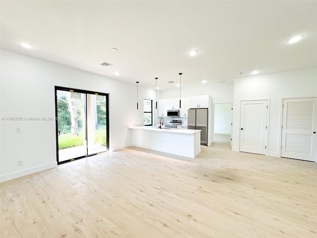 unfurnished living room with sink and light hardwood / wood-style flooring