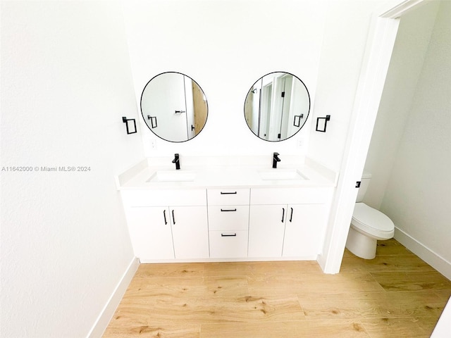 bathroom with hardwood / wood-style flooring, vanity, and toilet