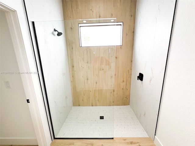 bathroom featuring tiled shower and tile patterned flooring