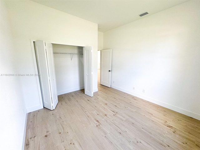 unfurnished bedroom featuring light wood-type flooring and a closet