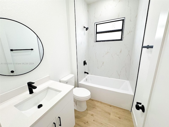 full bathroom with tiled shower / bath, hardwood / wood-style flooring, vanity, and toilet