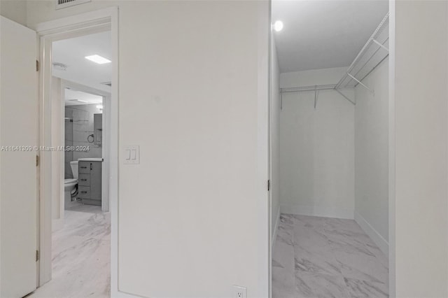 walk in closet with marble finish floor