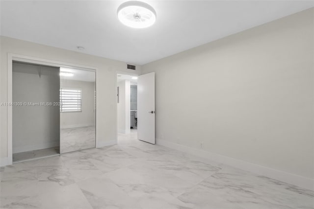 unfurnished bedroom with light tile patterned flooring and a closet