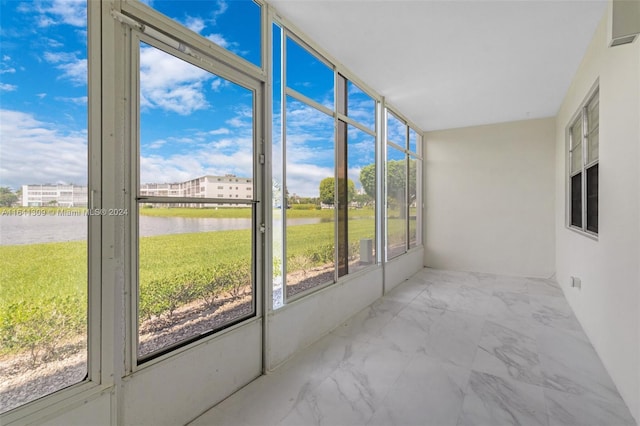 unfurnished sunroom featuring a water view