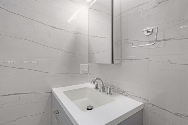 bathroom with vanity and tile walls