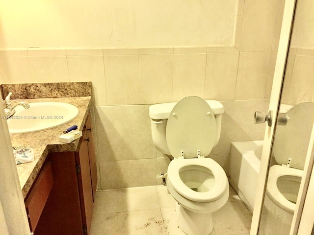 bathroom with vanity, tile walls, and toilet