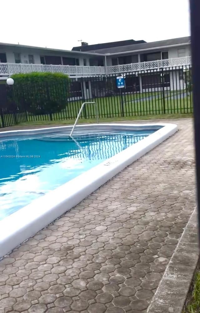 view of swimming pool with a yard