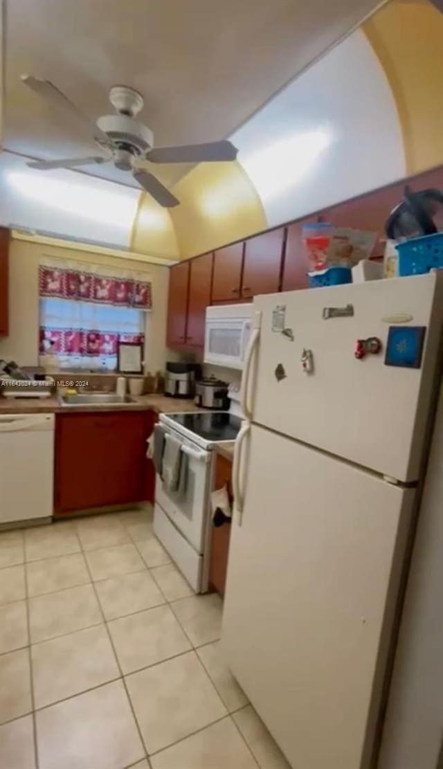 kitchen featuring light tile patterned floors, white appliances, ceiling fan, and sink