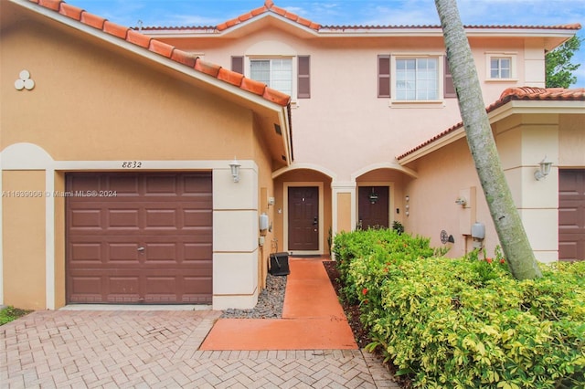 8832 S Isles Cir, Tamarac, FL 33321 - view of front facade with a tiled roof, stucco siding, an attached garage, and decorative driveway