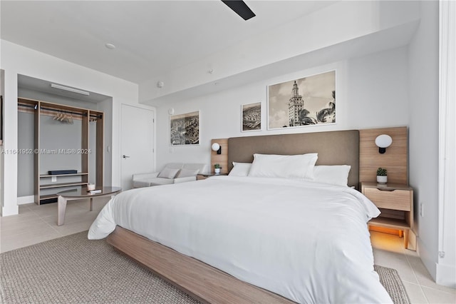 tiled bedroom with ceiling fan and a closet