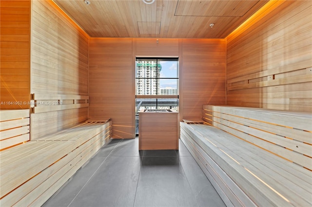 view of sauna with wood walls, concrete flooring, and wood ceiling