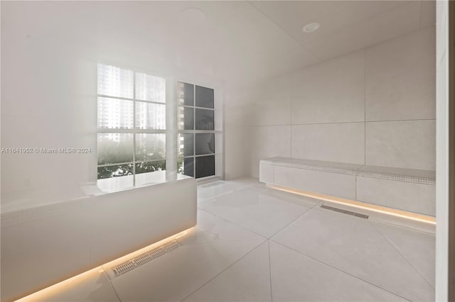 interior space featuring tile patterned flooring and tile walls