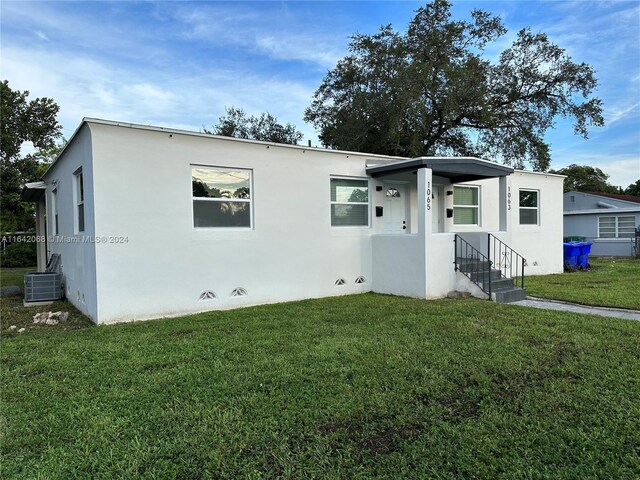 view of front facade with a front lawn and central AC