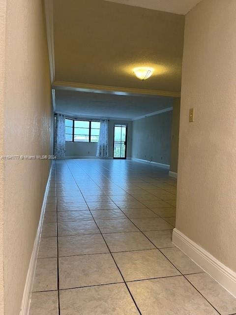 hallway with tile patterned flooring and ornamental molding