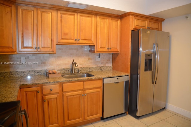 kitchen featuring appliances with stainless steel finishes, backsplash, light tile patterned flooring, and sink