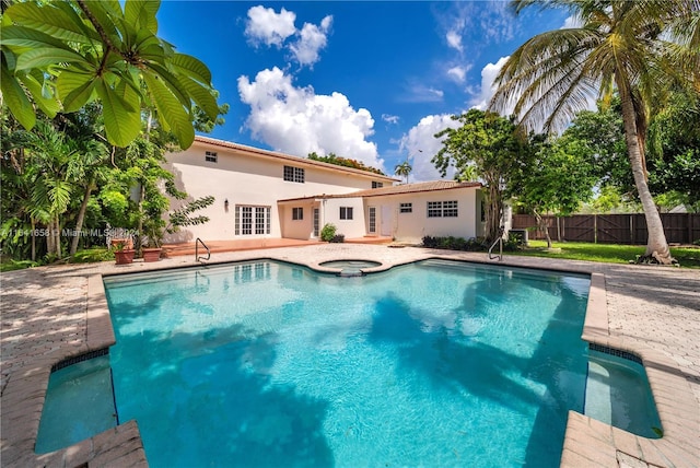 view of swimming pool featuring an in ground hot tub, a patio, and french doors