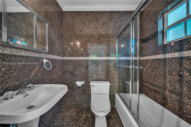 full bathroom featuring enclosed tub / shower combo, sink, tile walls, toilet, and ornamental molding