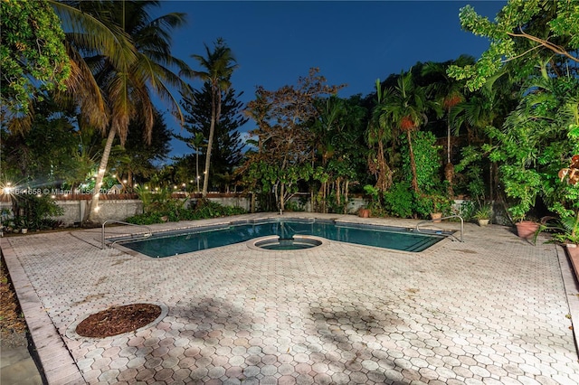 pool at twilight featuring a patio