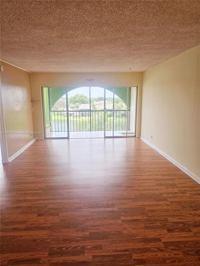 4025 N Nob Hill Rd Unit 507, Sunrise, FL 33351 - empty room featuring a textured ceiling, dark wood-style flooring, and baseboards