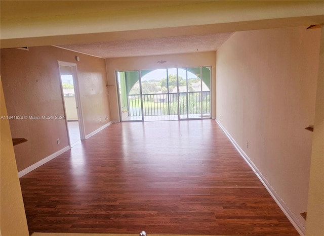 spare room featuring a textured ceiling and wood-type flooring