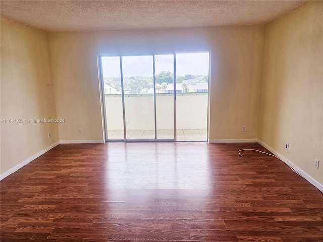 spare room with a textured ceiling and hardwood / wood-style floors