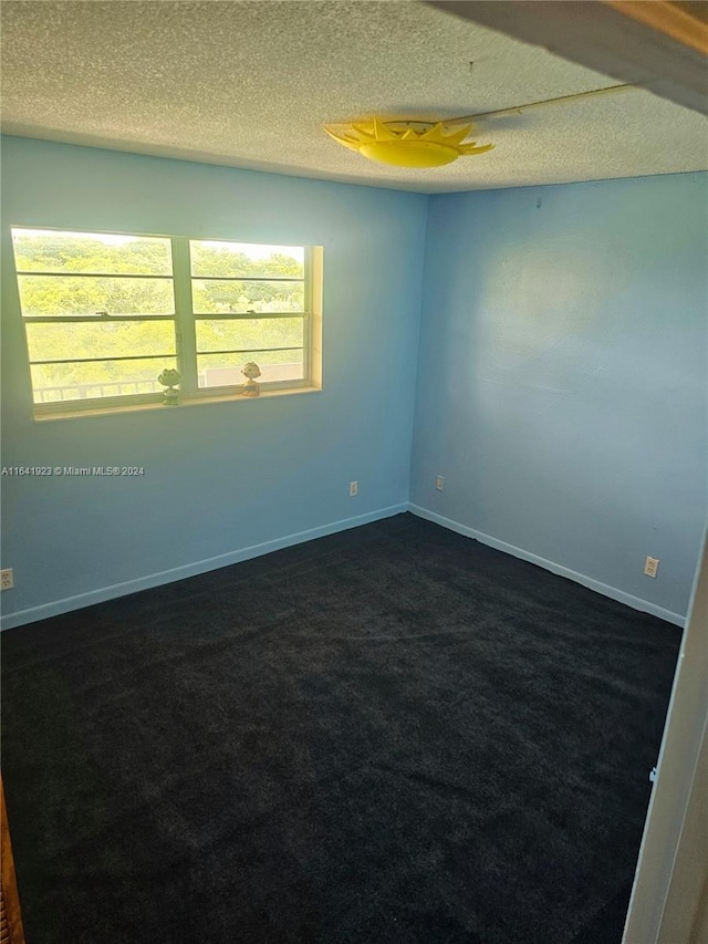 carpeted spare room featuring a textured ceiling