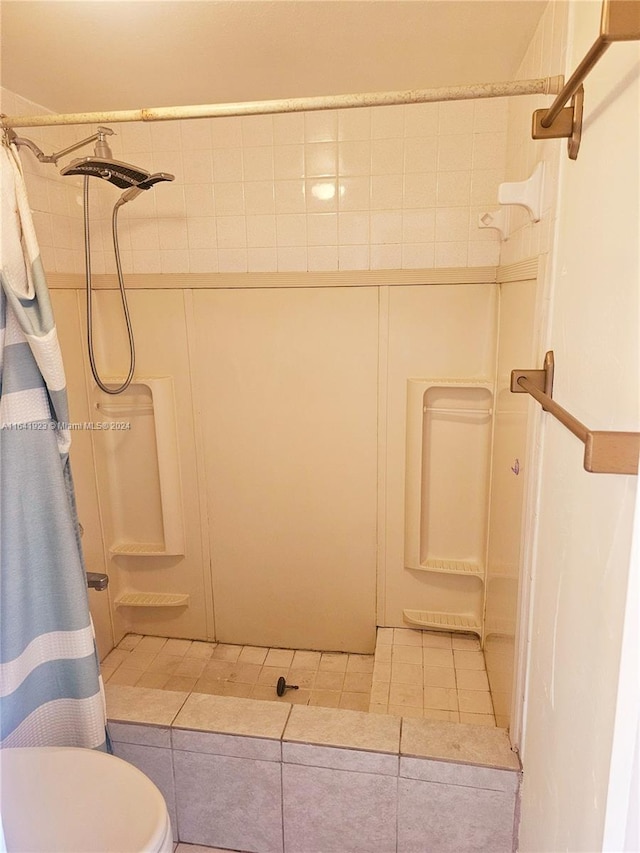 bathroom with curtained shower, tile patterned floors, and toilet