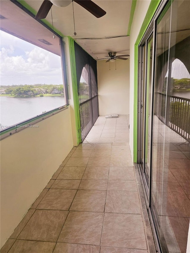 balcony featuring ceiling fan and a water view