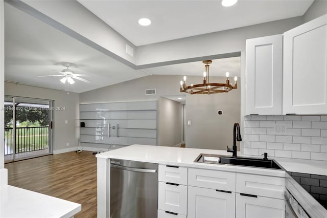 kitchen with tasteful backsplash, ceiling fan with notable chandelier, stainless steel dishwasher, hardwood / wood-style flooring, and sink