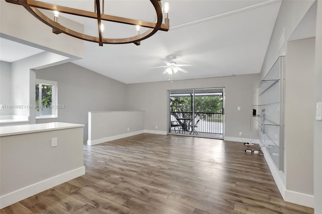 unfurnished living room featuring ceiling fan with notable chandelier and wood-type flooring