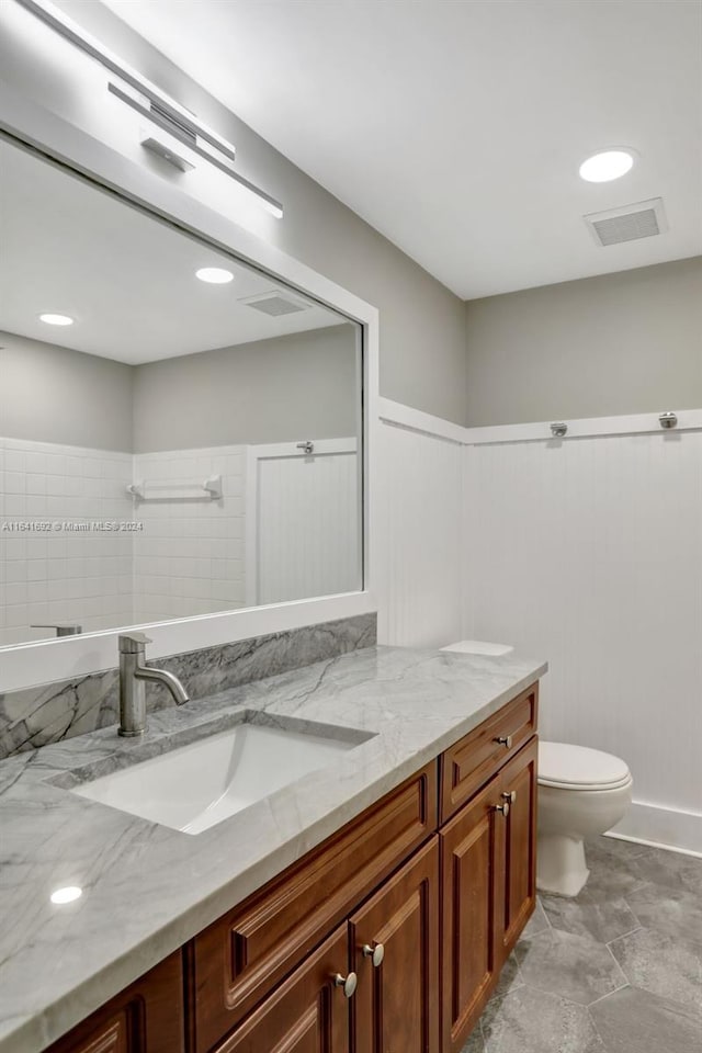 bathroom featuring vanity, tile patterned flooring, and toilet